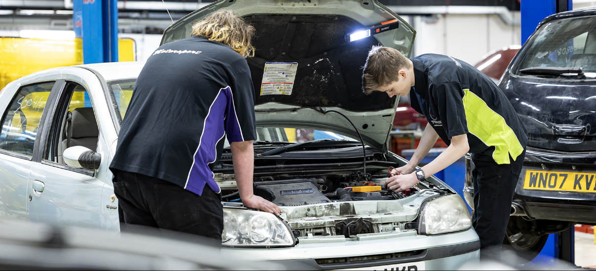 apprentices working on a car